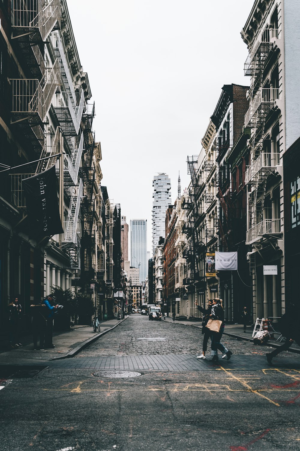 a man walking down a street next to tall buildings