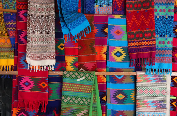 Vibrant hand-dyed textiles draped gracefully, revealing rich cultural patterns and textures.