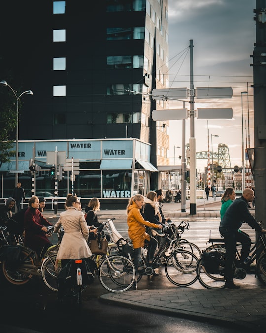 Grupo de pessoas pedalando juntas em um cruzamento urbano movimentado durante o trajeto diário