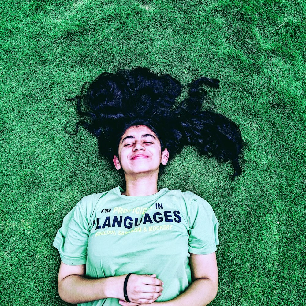 smiling woman lying on green grasses