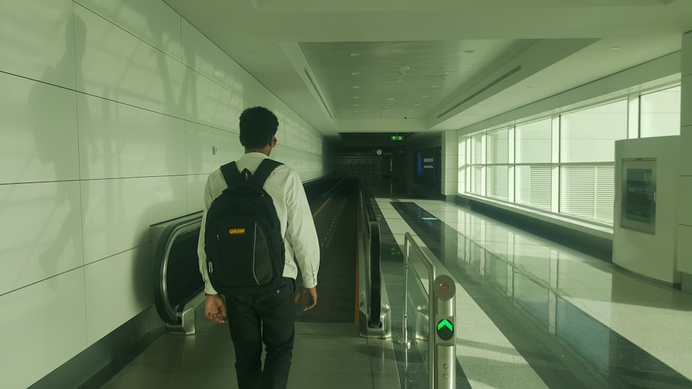 man walking inside building going on escalator