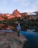 Smiling traveler standing beside a scenic mountain lake at sunset.