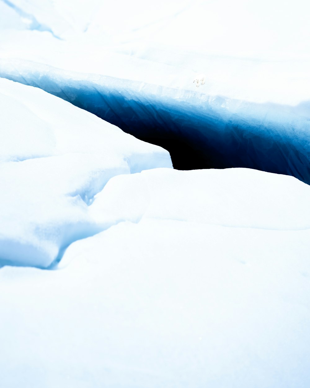 a deep blue hole in the snow