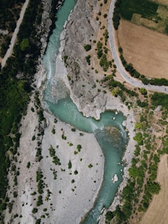 A high-altitude photo of a winding river cutting through a valley, highlighting natural curves.