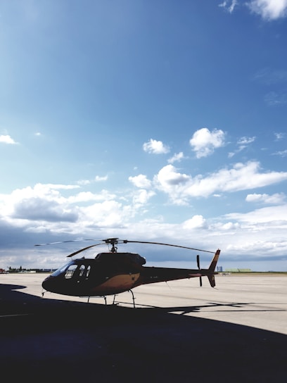 Technician inspecting a helicopter engine outdoors with clear blue sky background