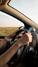 personne avec une montre blanche conduisant une voiture