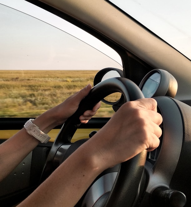 person with white watch driving car