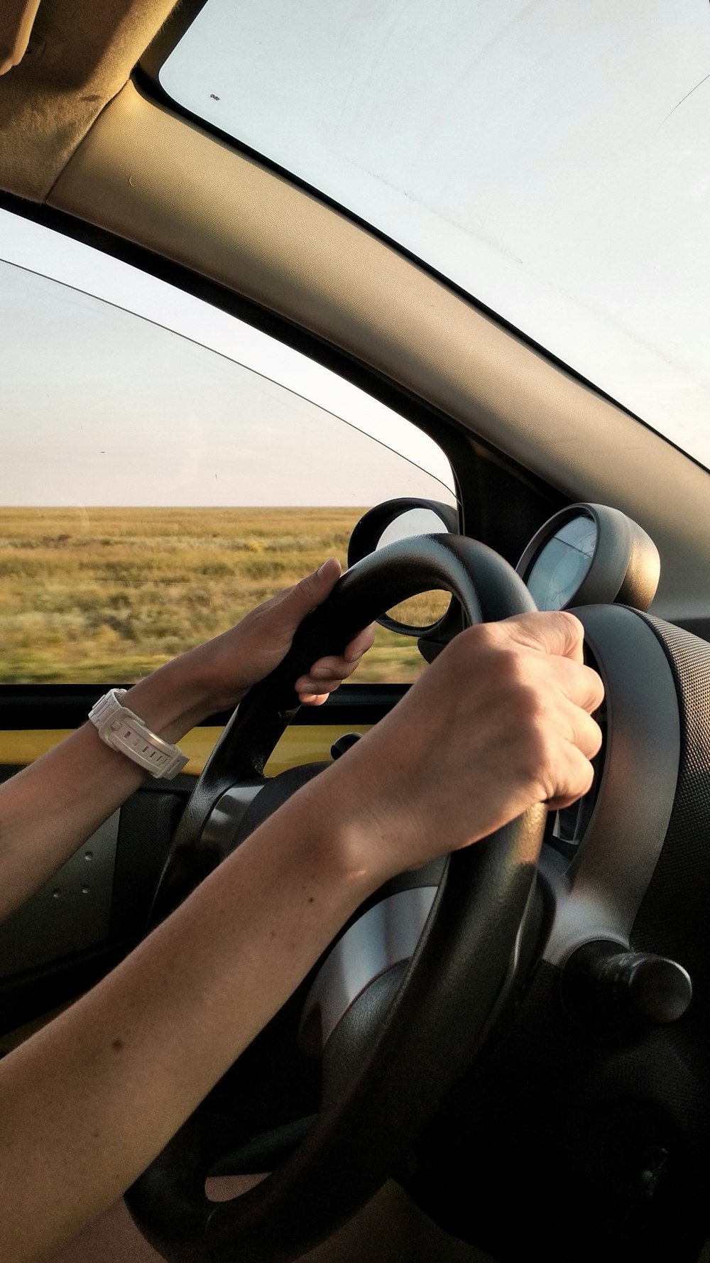 Person mit weißer Uhr, die Auto fährt