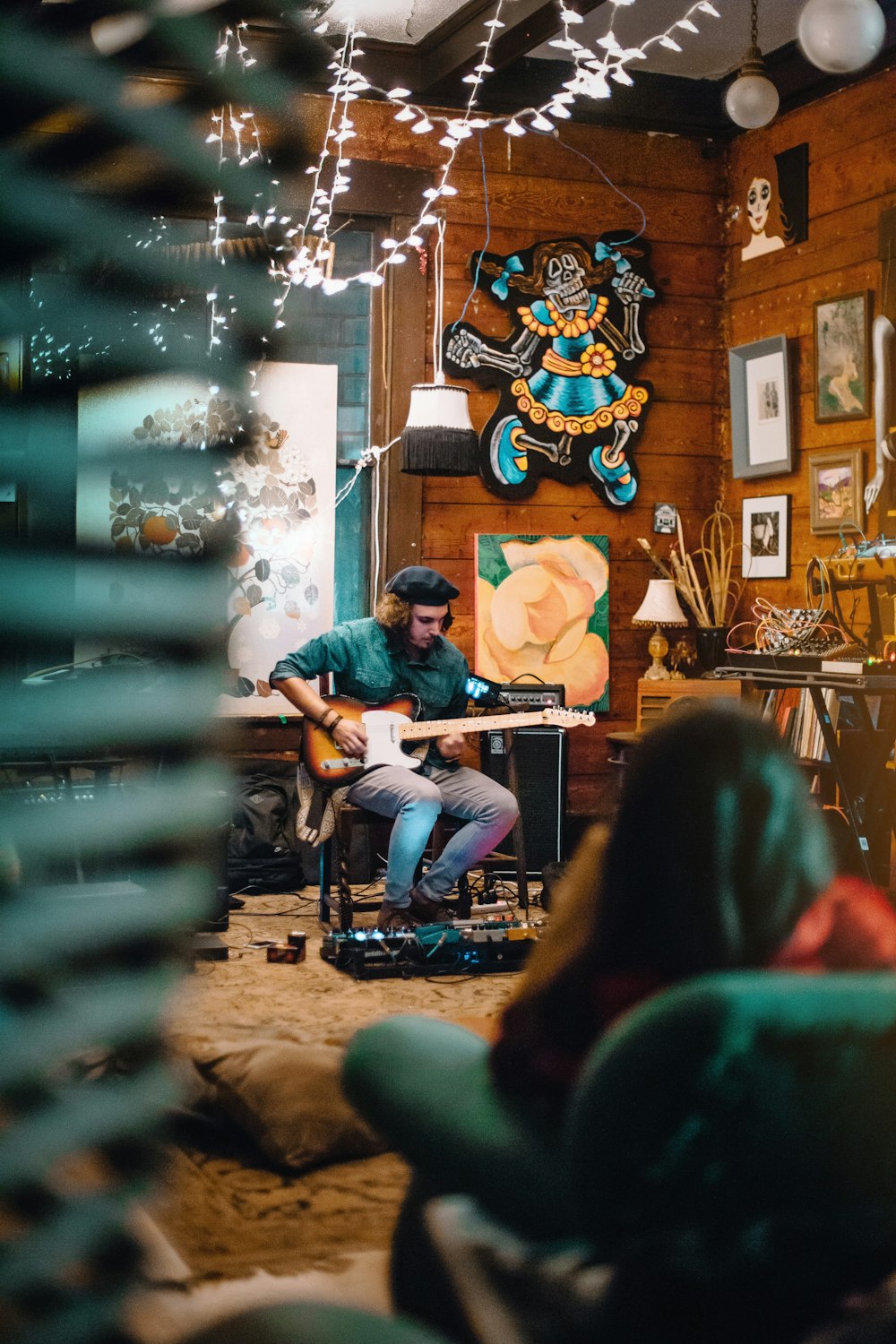 sitting man playing guitar across room