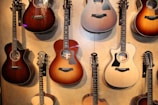Collection of finished guitars displayed on wooden stands with soft natural lighting