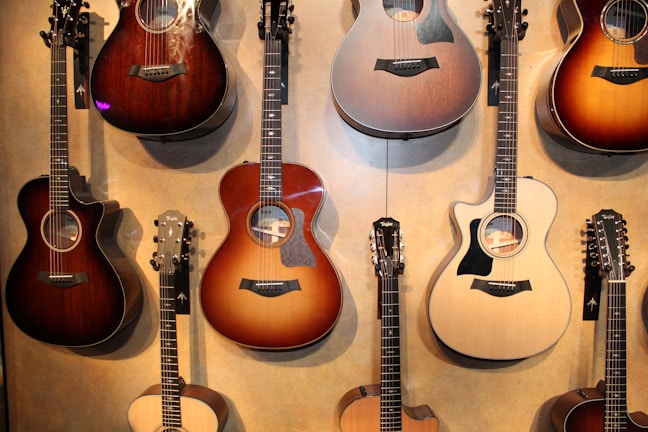 Collection of finished guitars displayed on wooden stands with soft natural lighting