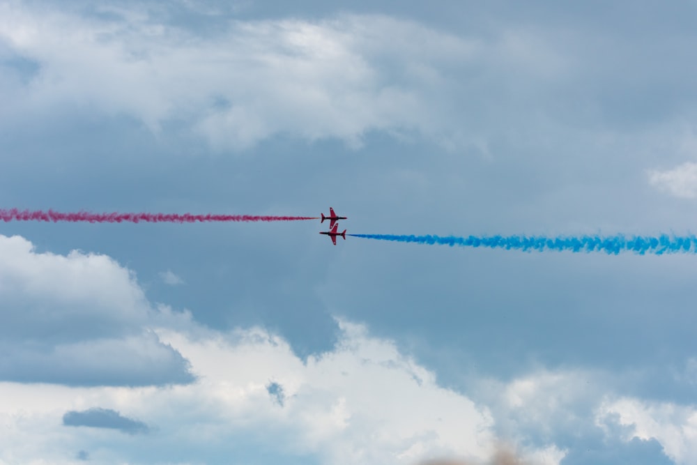 two planes with red and blue smoke