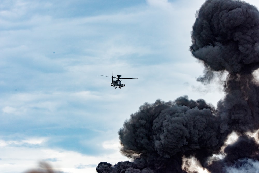 black helicopter beside black smoke