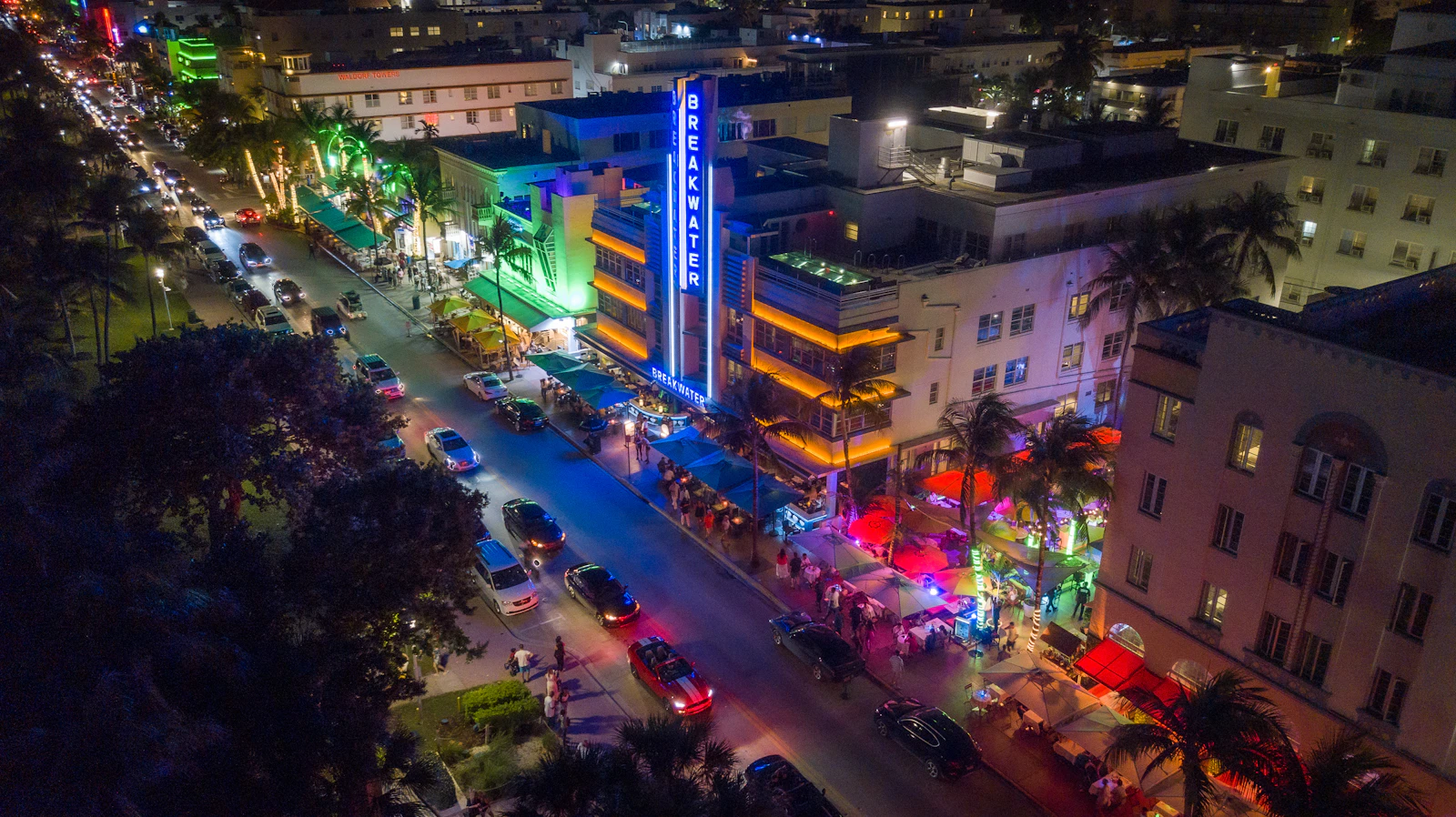 Aerial night view of Ocean Drive in Miami Beach with glowing Art Deco neon signs