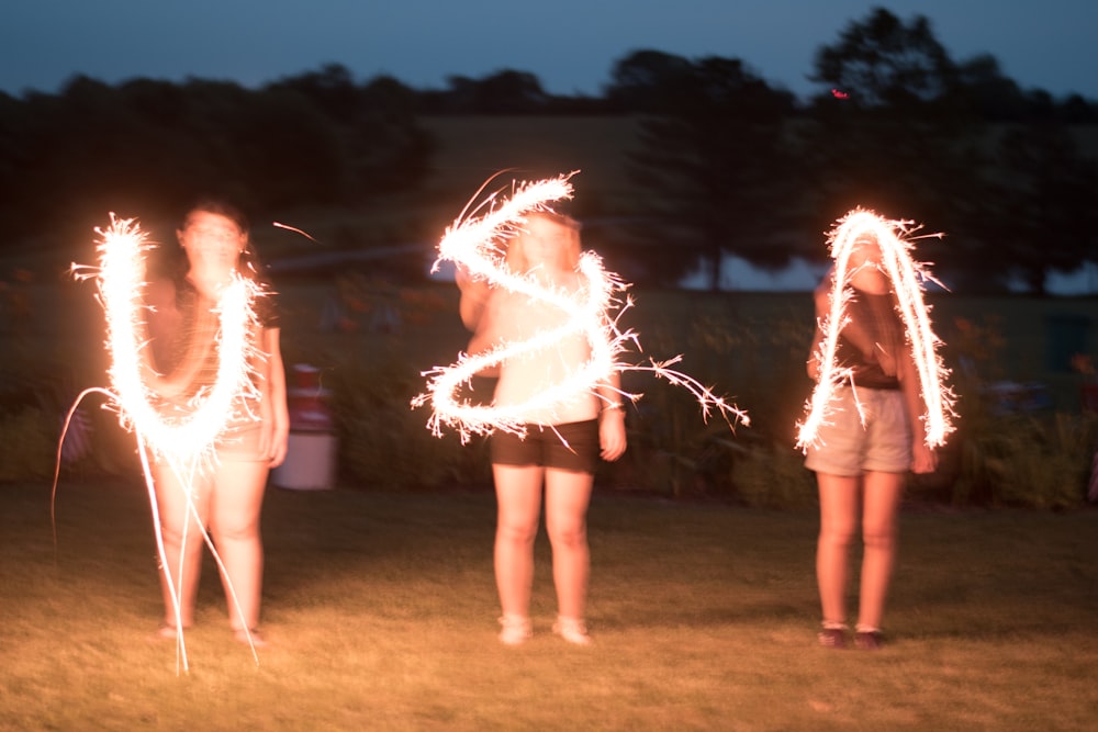 steel wool photography of three women near outdoor