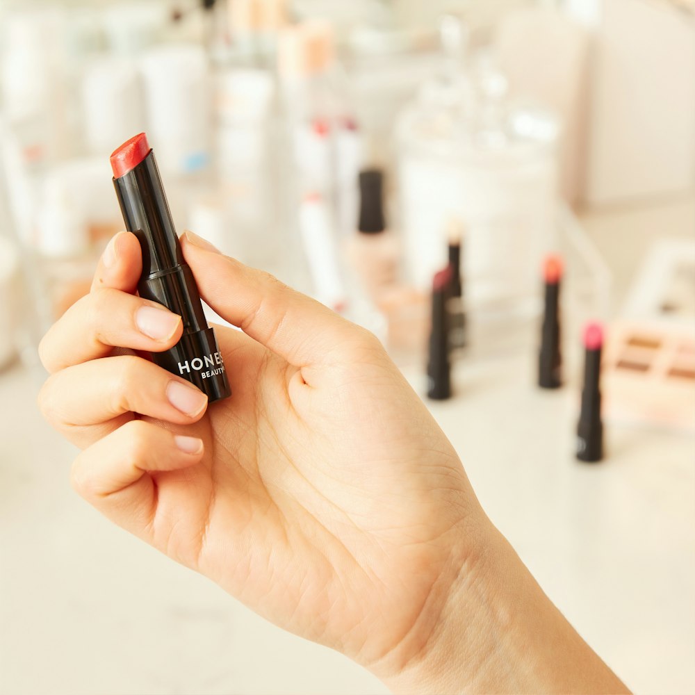 person holding lipstick