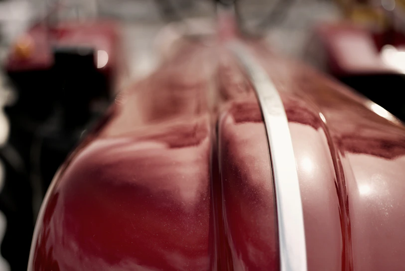 Close-up of a vibrant red powder-coated metal surface with a smooth finish.
