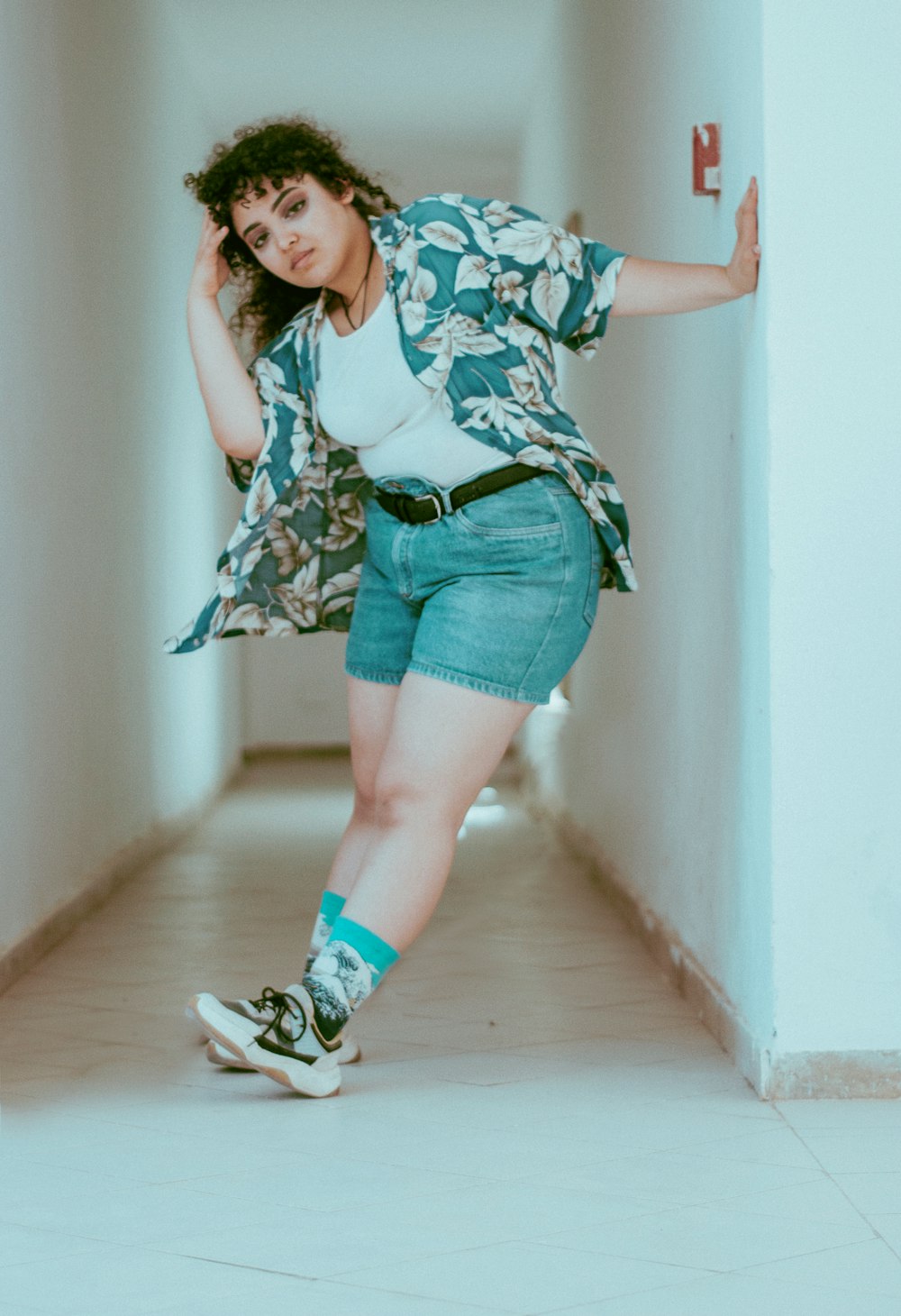 mujer sosteniendo una pared de hormigón blanco