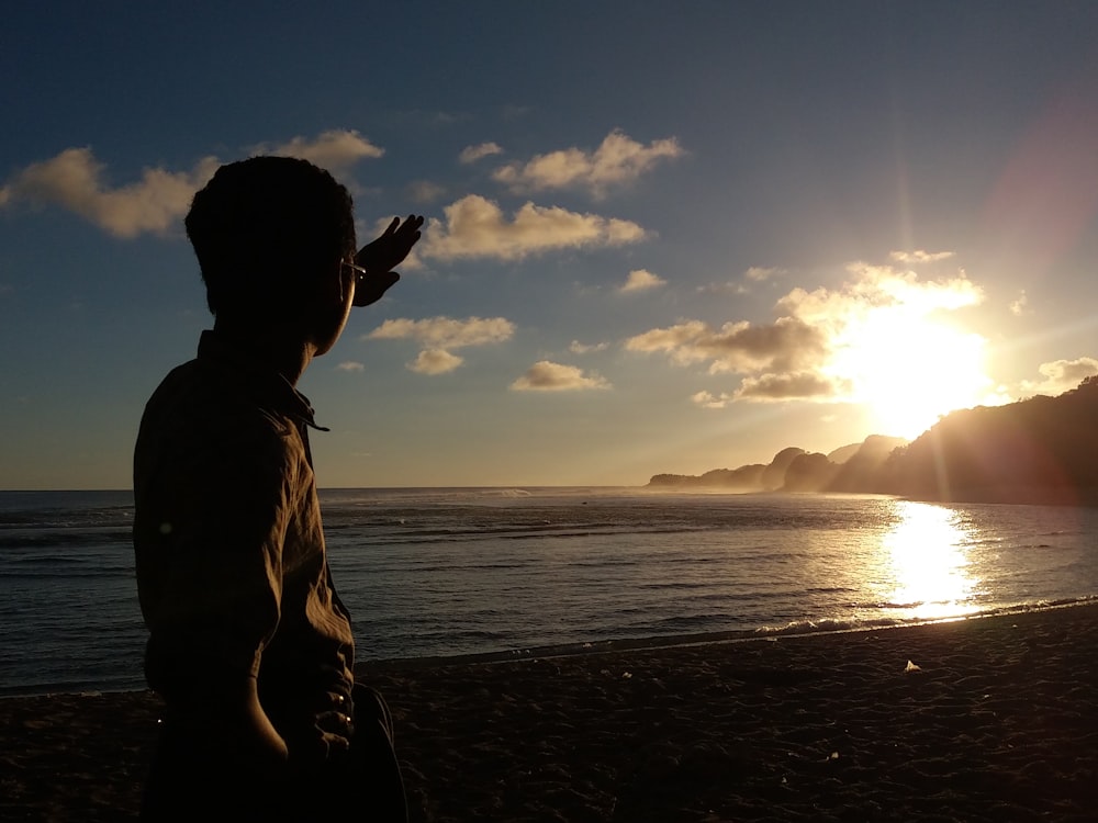 sunlight rays through beach with man standing on shore