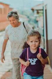 An adolescent walking outdoors receiving advice from a caring educator.