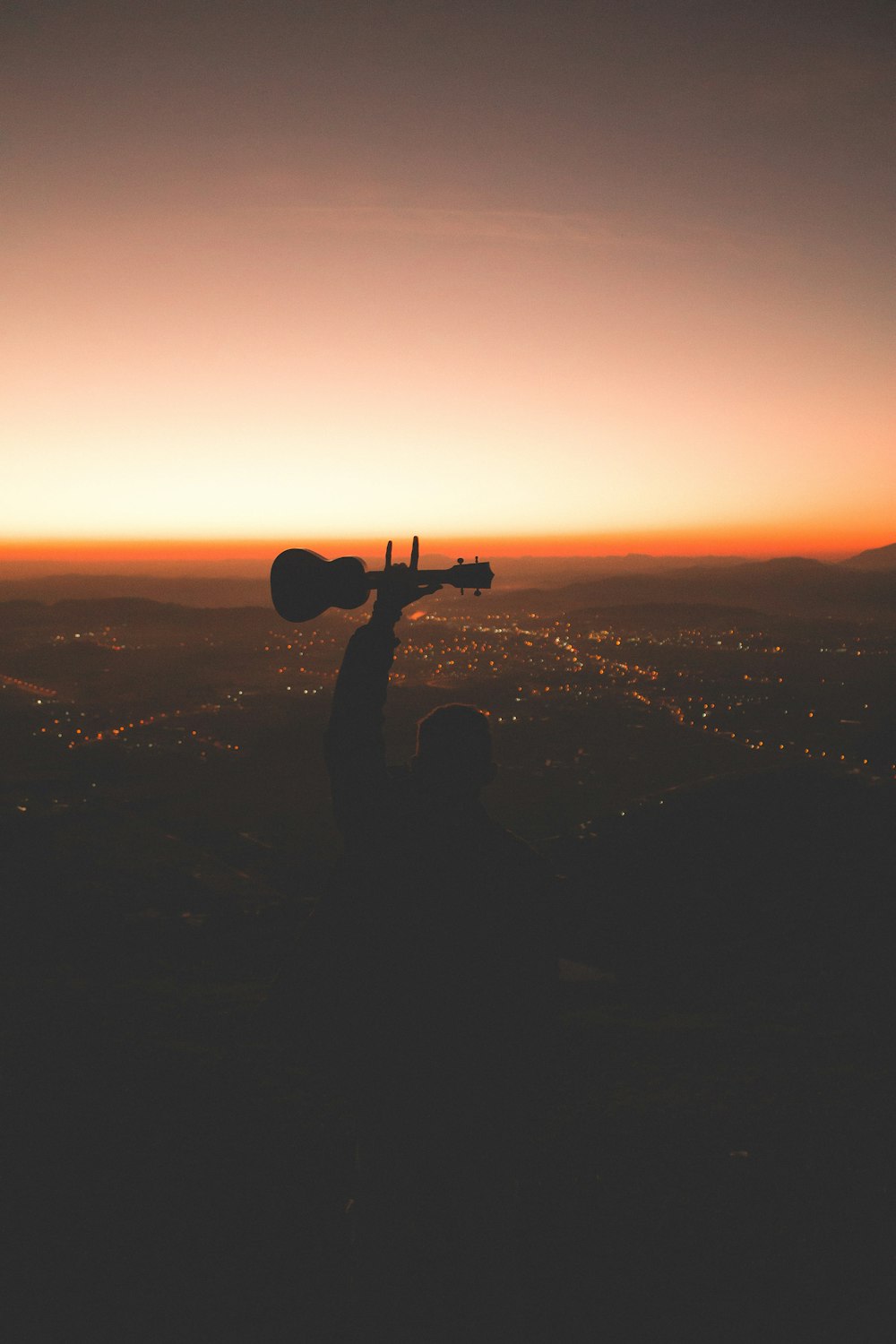 Fotografía de la silueta de la persona que sostiene la guitarra