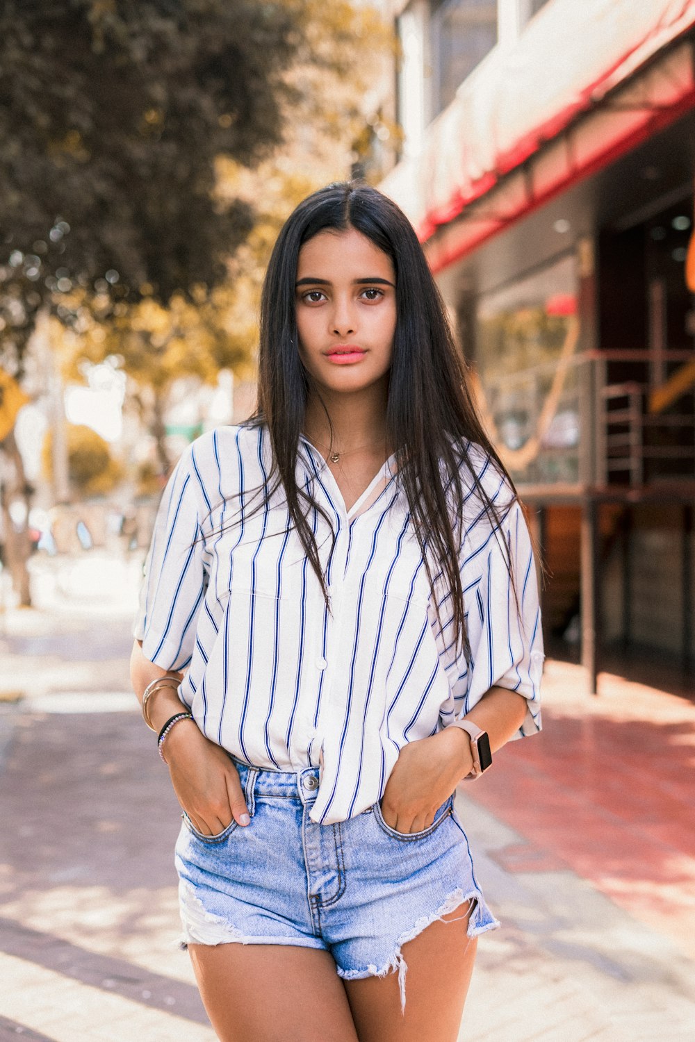 woman wearing blouse standing beside tree