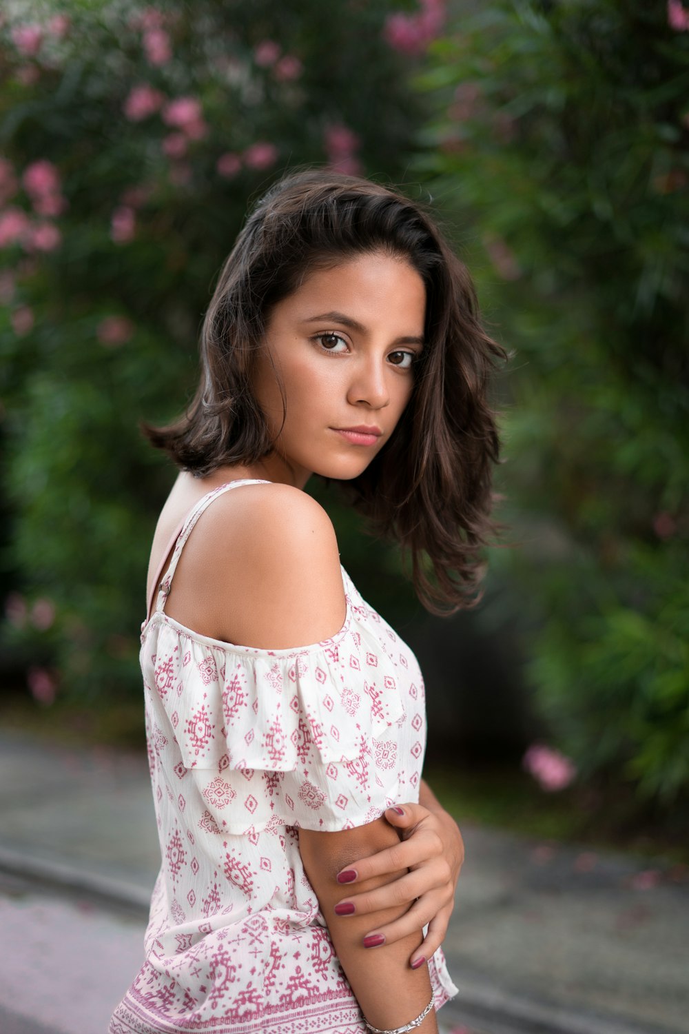 woman in white and pink floral cold-shoulder blouse