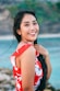 woman wearing white and red floral top across body of water