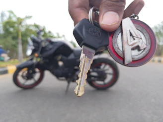 A friendly delivery person handing over a motorcycle key to a happy customer at their doorstep