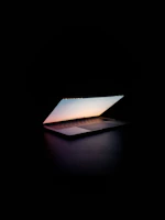 A laptop open on a wooden table, showing a calm video call interface in soft natural light