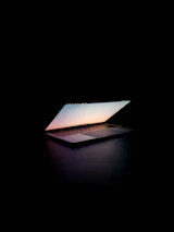 An inviting laptop screen showing a live prayer session with gentle purple and red hues.