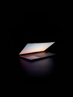 A peaceful moment of prayer with a glowing laptop displaying a virtual church service.