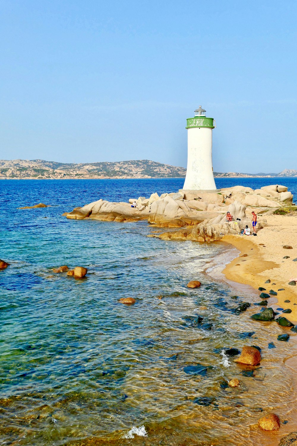 white lighthouse beside body of water