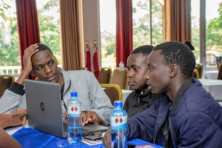 three men using laptops on table