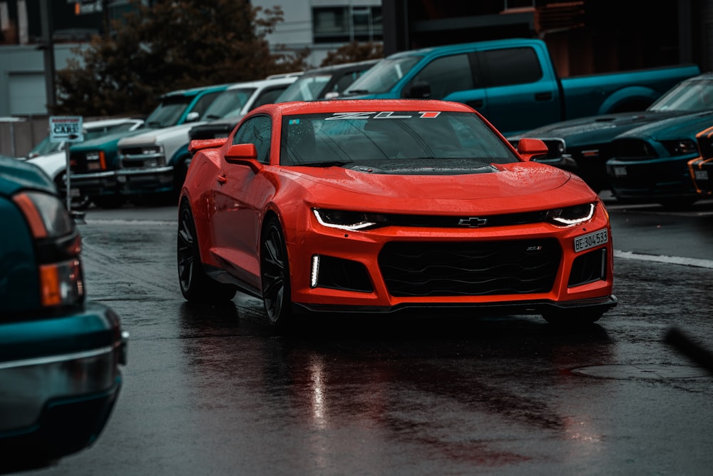 red sports coupe surrounded by vehicles