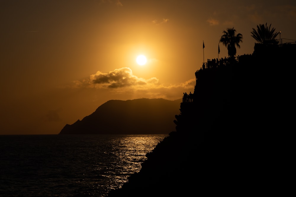 silhouette photography of mountain beside body water