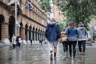 A group of friends walking through a historic city street.