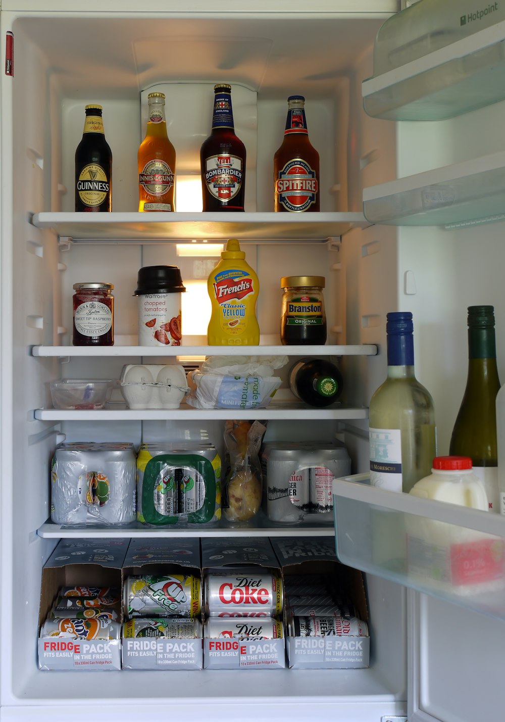 assorted beverage bottles and cans in refrigerator