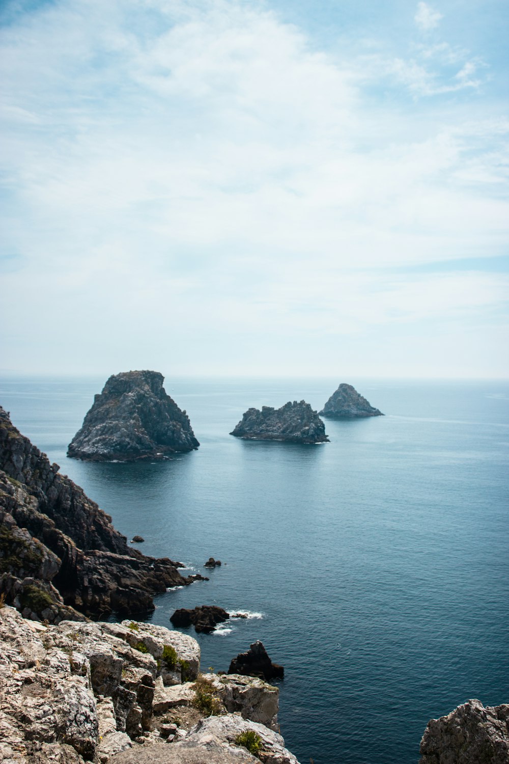 photography of rock formation on body of water during daytime