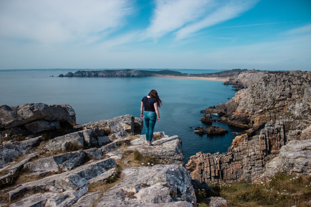 woman standing on big rock during daytime