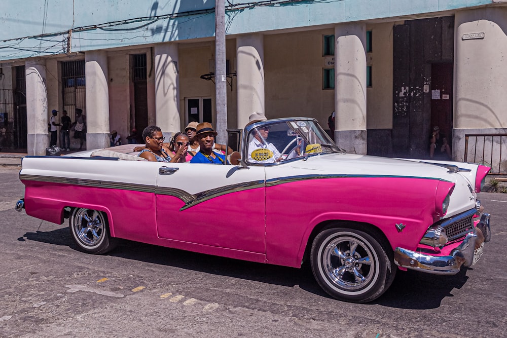 people in pink and white convertible coupe