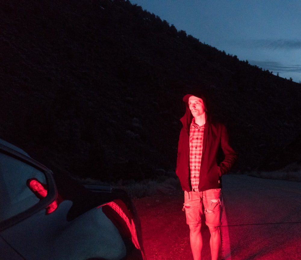 man wearing black hooded jacket at nighttime