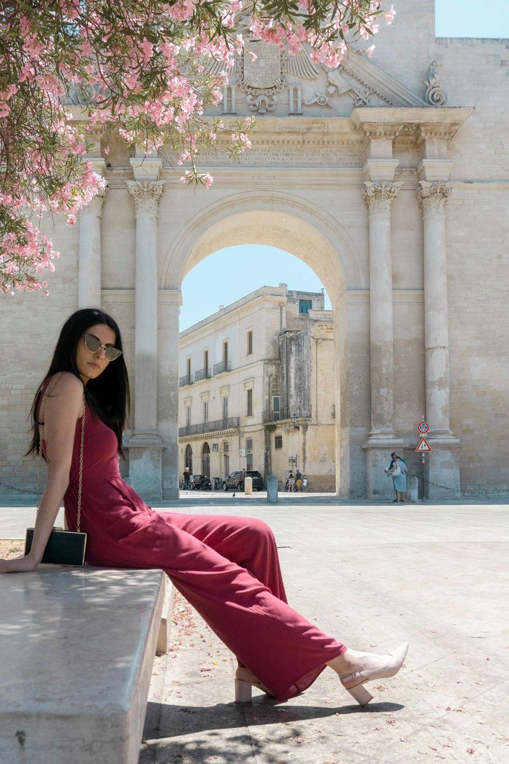 woman sitting on concrete bench under the tree during daytime