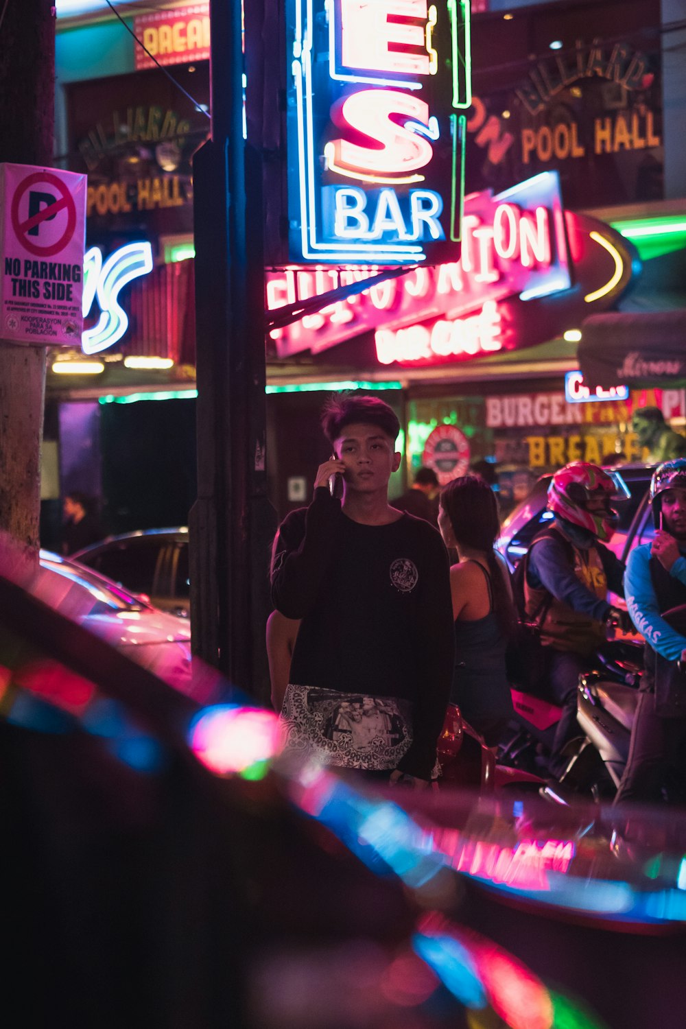 man standing beside neon signage