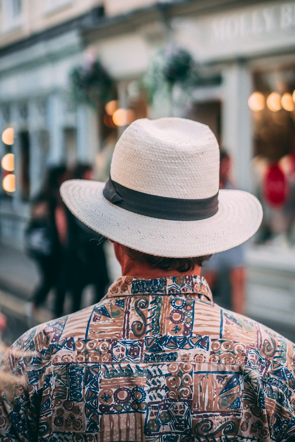 uomo che indossa cappello bianco e camicia marrone