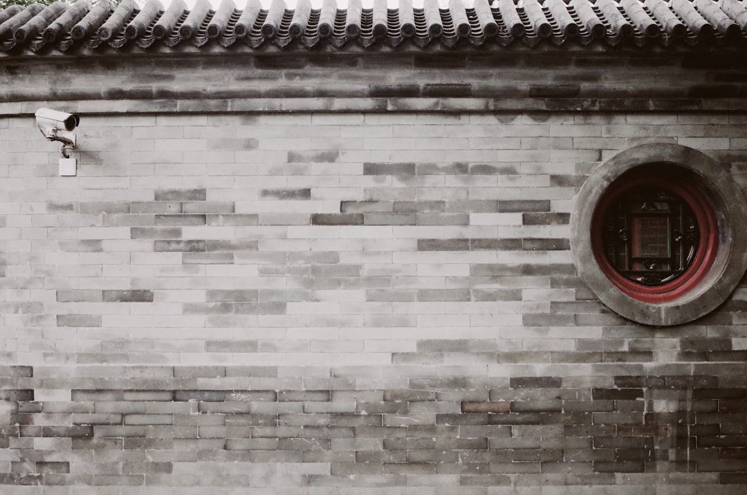 brown and gray brick wall with mounted CCTV camera