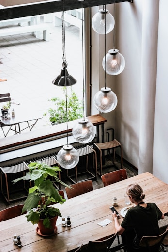 woman in black shirt sitting by the table