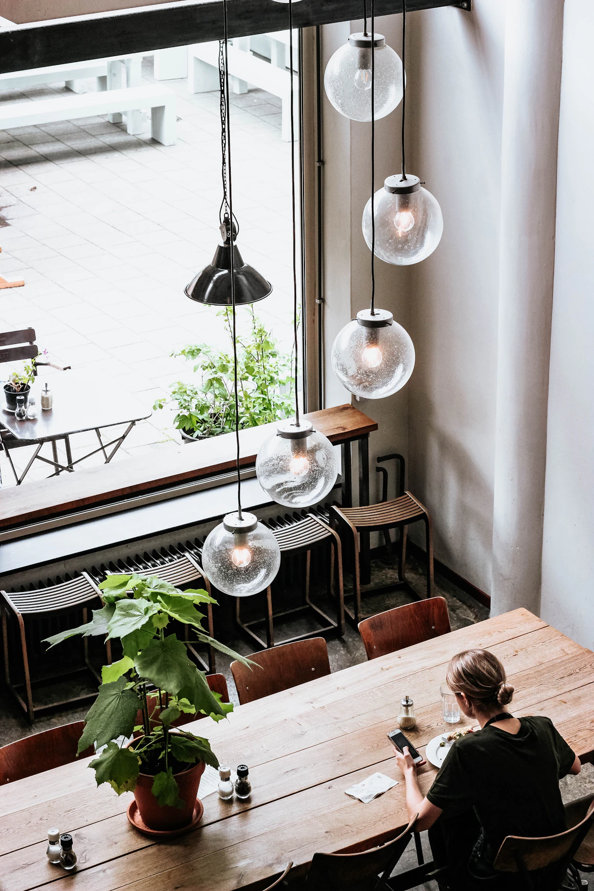 Woman enjoying quality solo time at a cozy cafe table with coffee and food