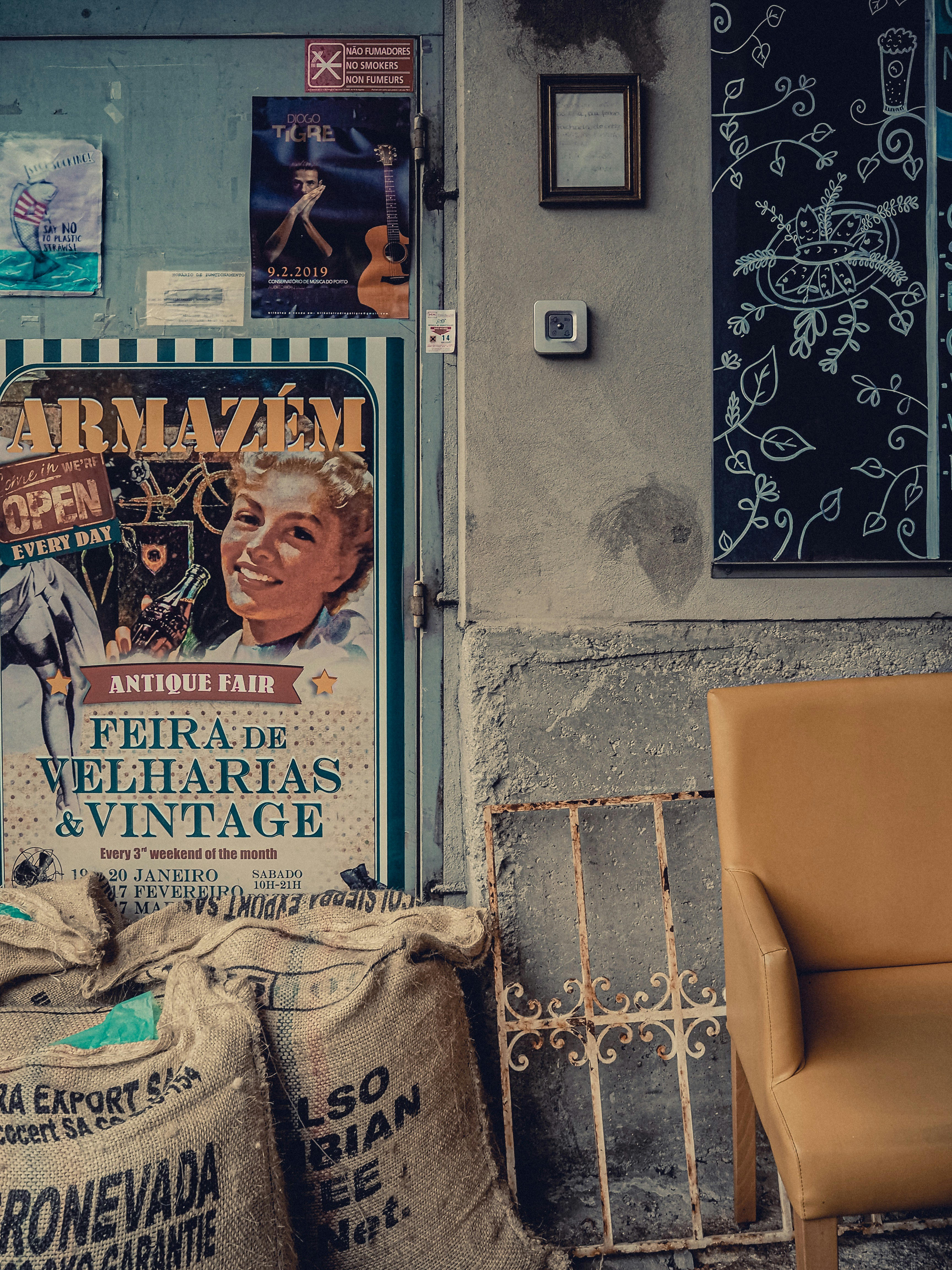 une chaise assise à côté d’un mur avec des affiches dessus