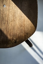 A close-up of a mid-century wooden chair showing detailed craftsmanship and wear.